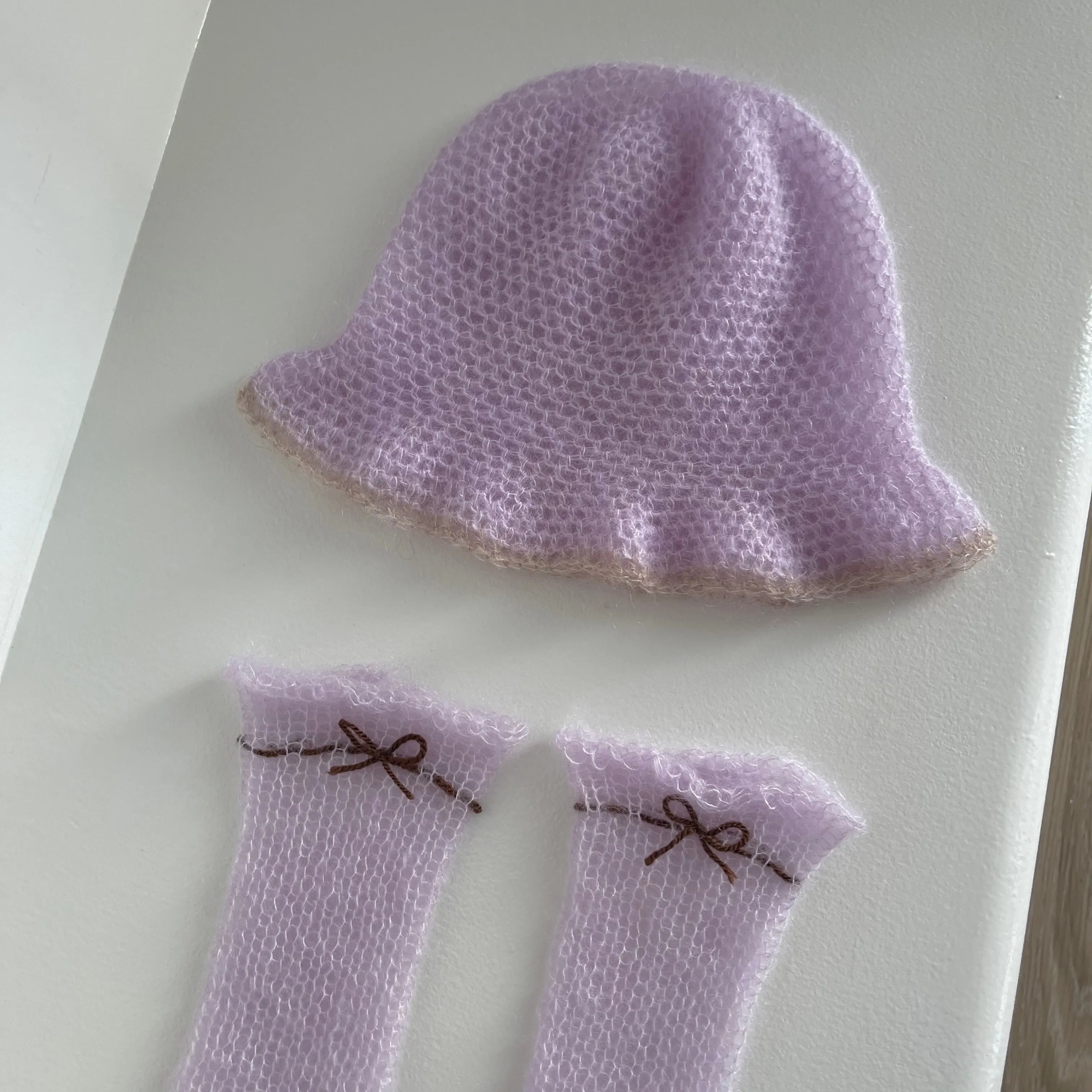 Handmade knitted mohair hand warmers in lilac with brown bow